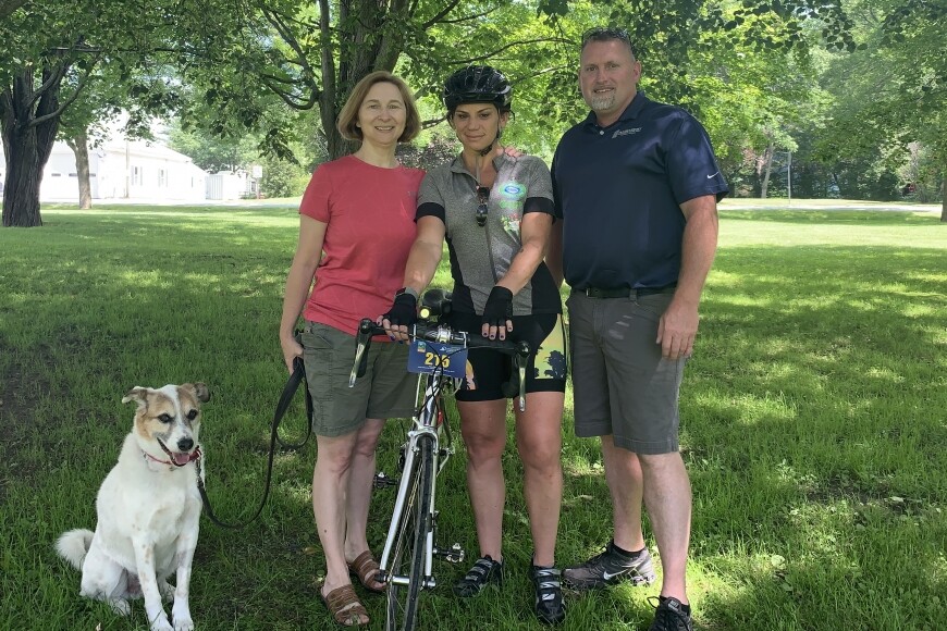 three people smiling with dog