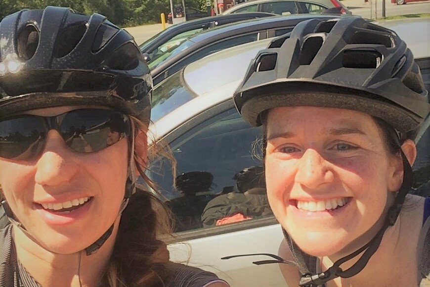 two people smiling with bike helmets