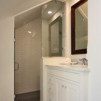 Modern bathroom featuring a glass shower, vanity, and hexagonal tile flooring.