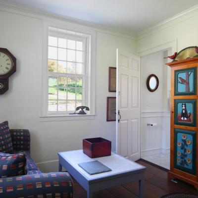 Cozy room featuring a clock, patterned sofa, and a decorative cabinet.