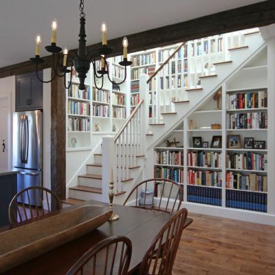 Modern kitchen and dining area with a staircase and built-in bookshelves.