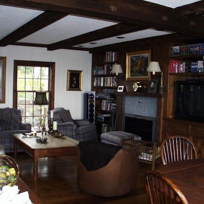 Cozy living room with plaid chairs, wooden furniture, and a bookshelf.