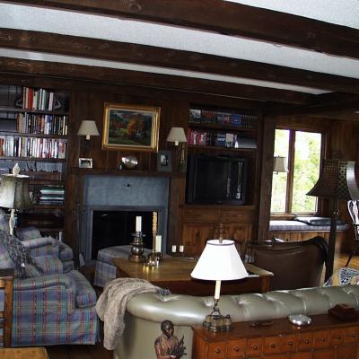 Cozy living room with wooden beams, bookshelves, and comfortable seating.
