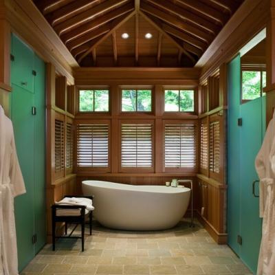 Spa-like bathroom featuring a freestanding tub, wooden accents, and natural light.