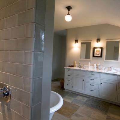 Spacious, modern bathroom featuring dual sinks, mirrors, and a glass shower wall.