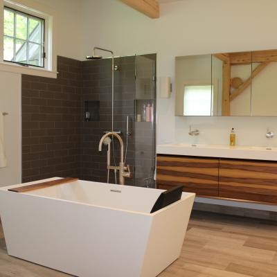 Modern bathroom featuring a freestanding tub, shower, and sleek wooden cabinetry.