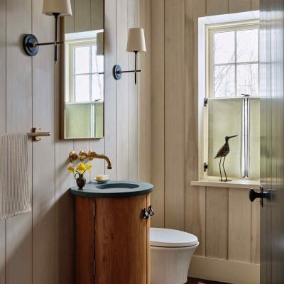 Modern bathroom with wood accents, a round sink, floral decor, and a window view.