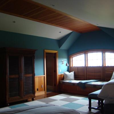 Bright bedroom with a wooden closet, window seat, and a cozy atmosphere.