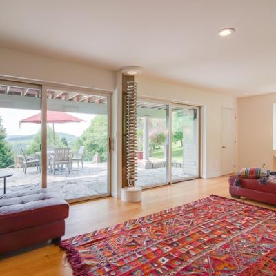 Bright living room with large windows, a colorful rug, and patio access.