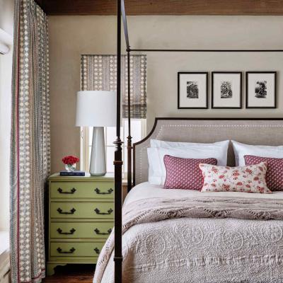 Cozy bedroom featuring a four-poster bed, green nightstand, and floral decor.