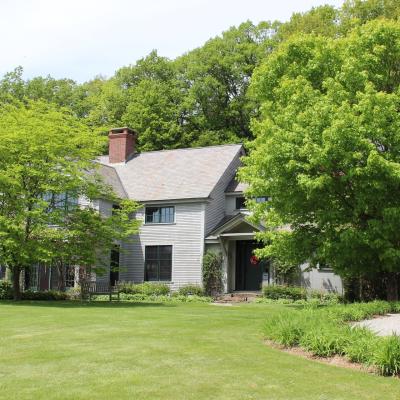 A charming house surrounded by lush greenery and a well-kept lawn.