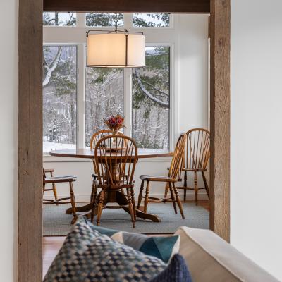 Cozy dining area with wooden chairs and a table, framed by a rustic doorway.