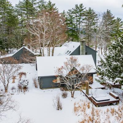Snow-covered houses nestled among trees in a winter landscape.