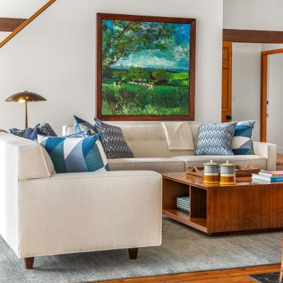 Cozy living room with a light sofa, colorful pillows, and a wooden coffee table.