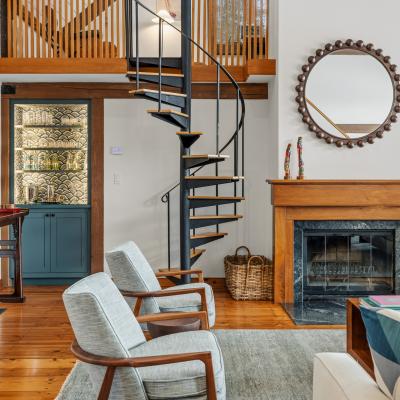 Stylish living space with spiral staircase, fireplace, and modern furnishings.