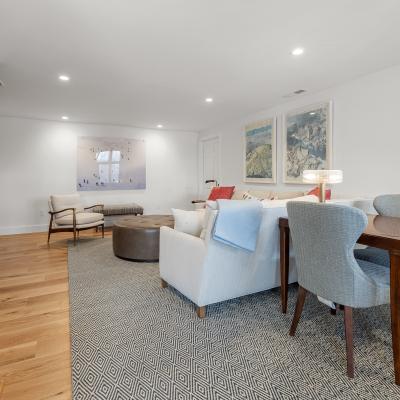 Bright, modern living area with chairs, a table, and artwork on white walls.