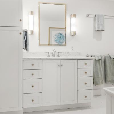 Modern bathroom with a white cabinet, marble countertop, and soft green towels.