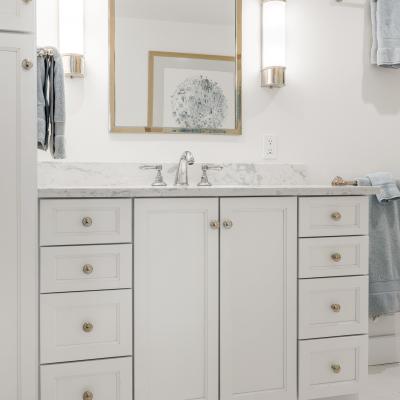 Modern bathroom with a marble countertop, mirror, and elegant lighting.