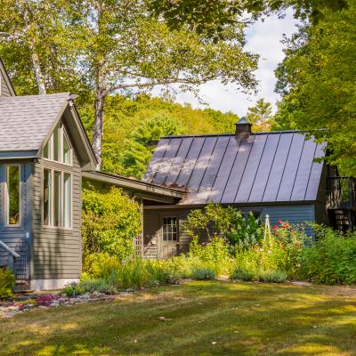 Home with Accessory Building lush gardens surrounded by trees in a serene outdoor setting.