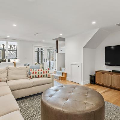 Comfortable modern living room with a sectional sofa, ottoman, and large TV.