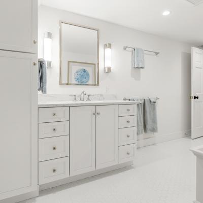 Modern white bathroom with a double sink, mirror, and soft blue accents.