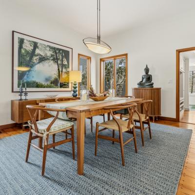 Bright dining area featuring a wooden table, chairs, and scenic window views.