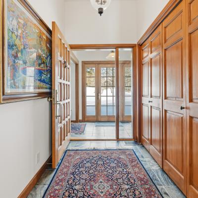 Bright hallway featuring wooden doors, closet space, and a vibrant artwork.