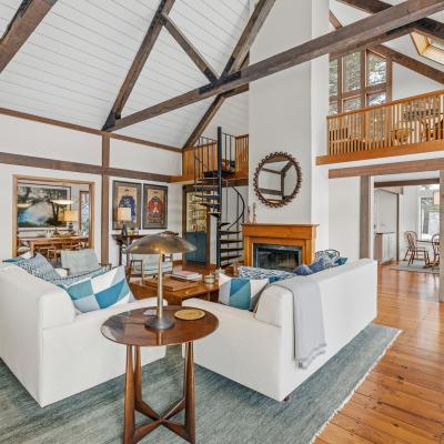 Spacious living room with vaulted ceiling, wooden beams, and cozy seating area.
