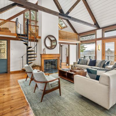 Modern living room with a spiral staircase, large windows, and stylish furniture.