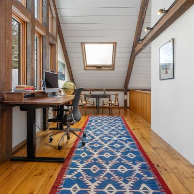 Bright, modern workspace with wooden accents and a colorful rug.