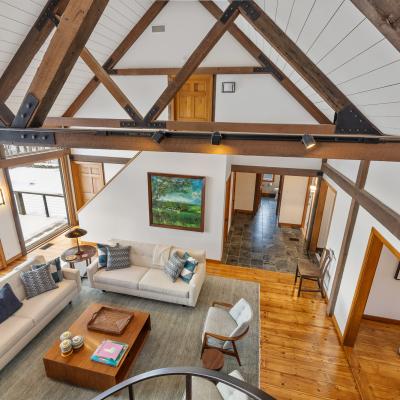 Bright, airy living room with wooden beams, stylish furniture, and large windows.