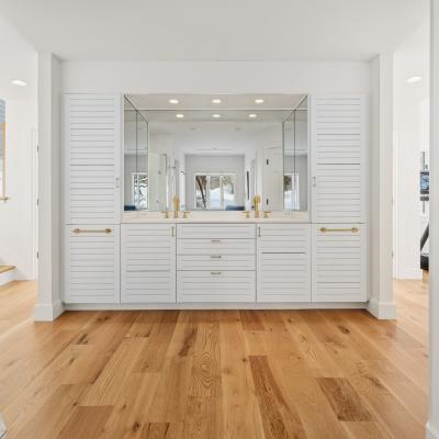 Bright, modern bathroom with a large double vanity and wooden floors.