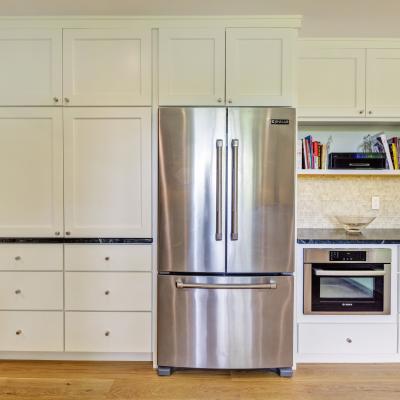 Modern kitchen featuring stainless steel appliances and white cabinetry.