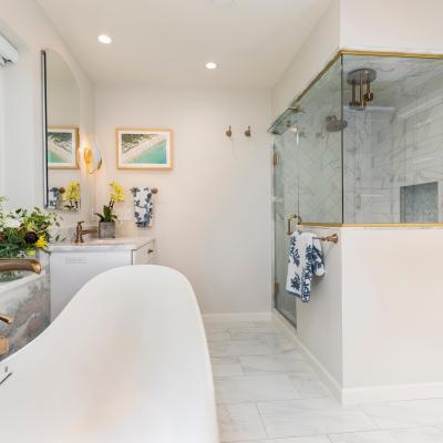 Modern bathroom with a freestanding tub, shower, and natural light from large window.