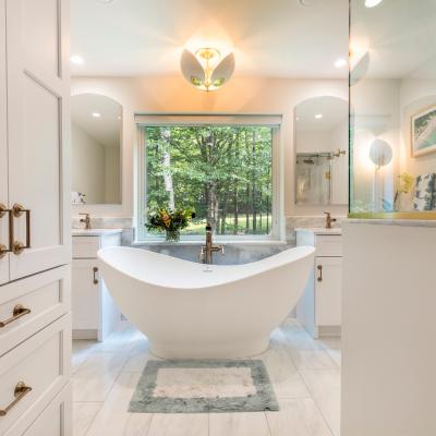 Modern bathroom featuring a freestanding tub, greenery view, and elegant fixtures.
