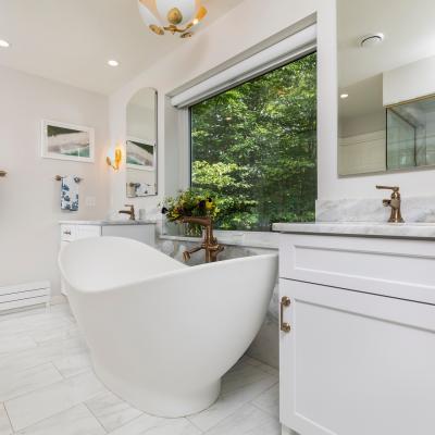 Modern bathroom with a freestanding tub, natural light, and elegant decor.
