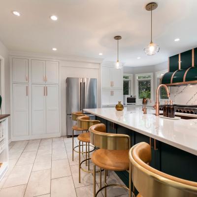 Modern kitchen with green accents, marble countertops, and stylish bar stools.