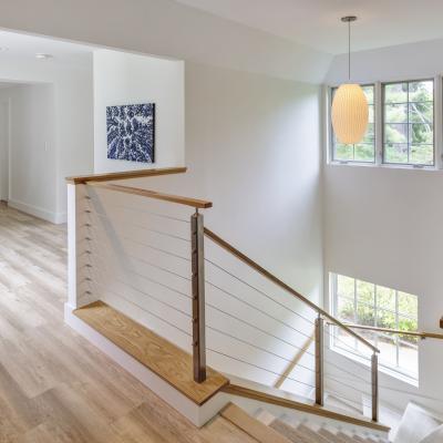 Bright, modern staircase with wood details and large windows.