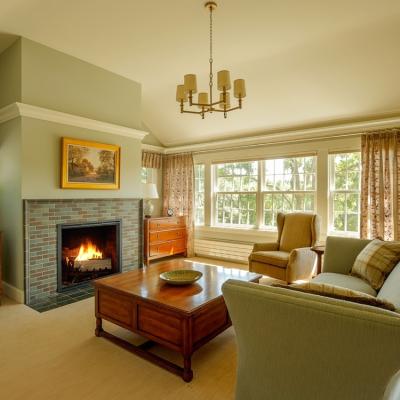 Cozy living room with a fireplace, large windows, and tasteful furnishings.