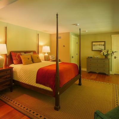 Cozy bedroom featuring a four-poster bed, nightstands, and warm lighting.