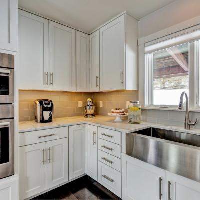 Modern kitchen with stainless steel appliances, a farmhouse sink, and a bright countertop.