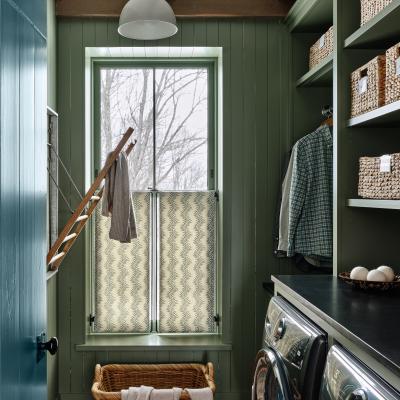 Bright laundry room with green walls, shelving, basket, and modern washing machines.