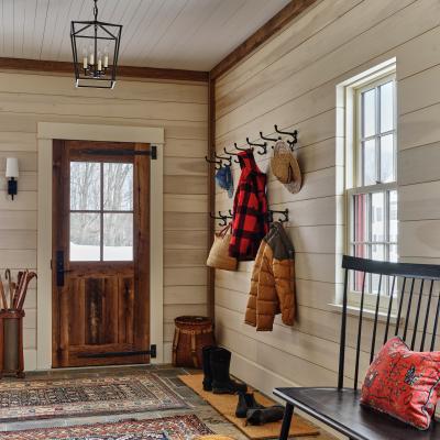 Cozy mudroom with wooden door, hooks for coats, and a patterned rug.