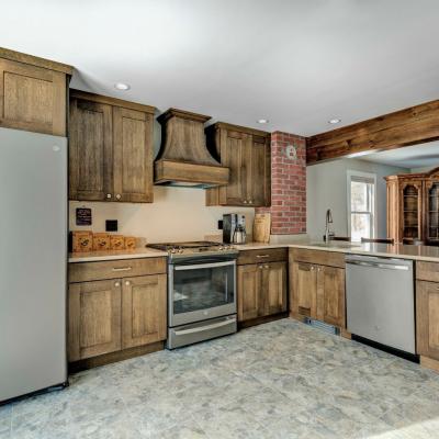 Modern kitchen with wood cabinets, stainless appliances, and brick accent wall.