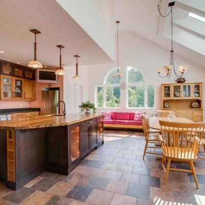 Bright, spacious kitchen with wood accents, dining area, and large windows.