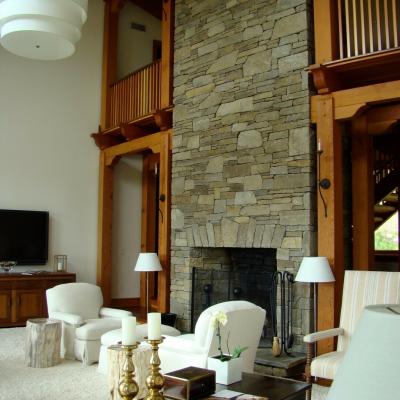 Spacious, modern living room with a stone fireplace and stylish furnishings.