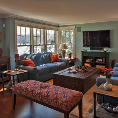 Cozy living room with blue sofas, a coffee table, and large windows overlooking a lake.