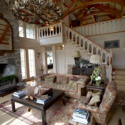 Cozy living room with antler chandelier, patterned sofas, and a wooden coffee table.