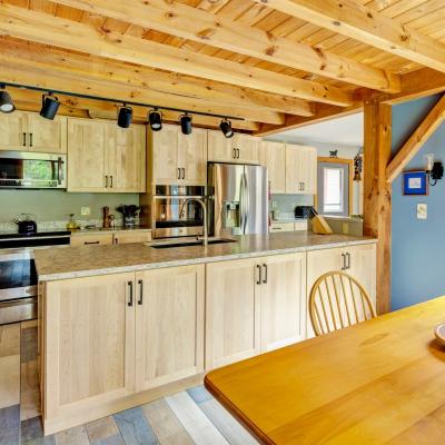 Modern kitchen with wood cabinets, granite countertops, and a wooden dining table.