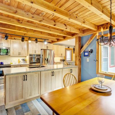 Bright kitchen with wooden cabinets, granite countertops, and a dining area by the window.